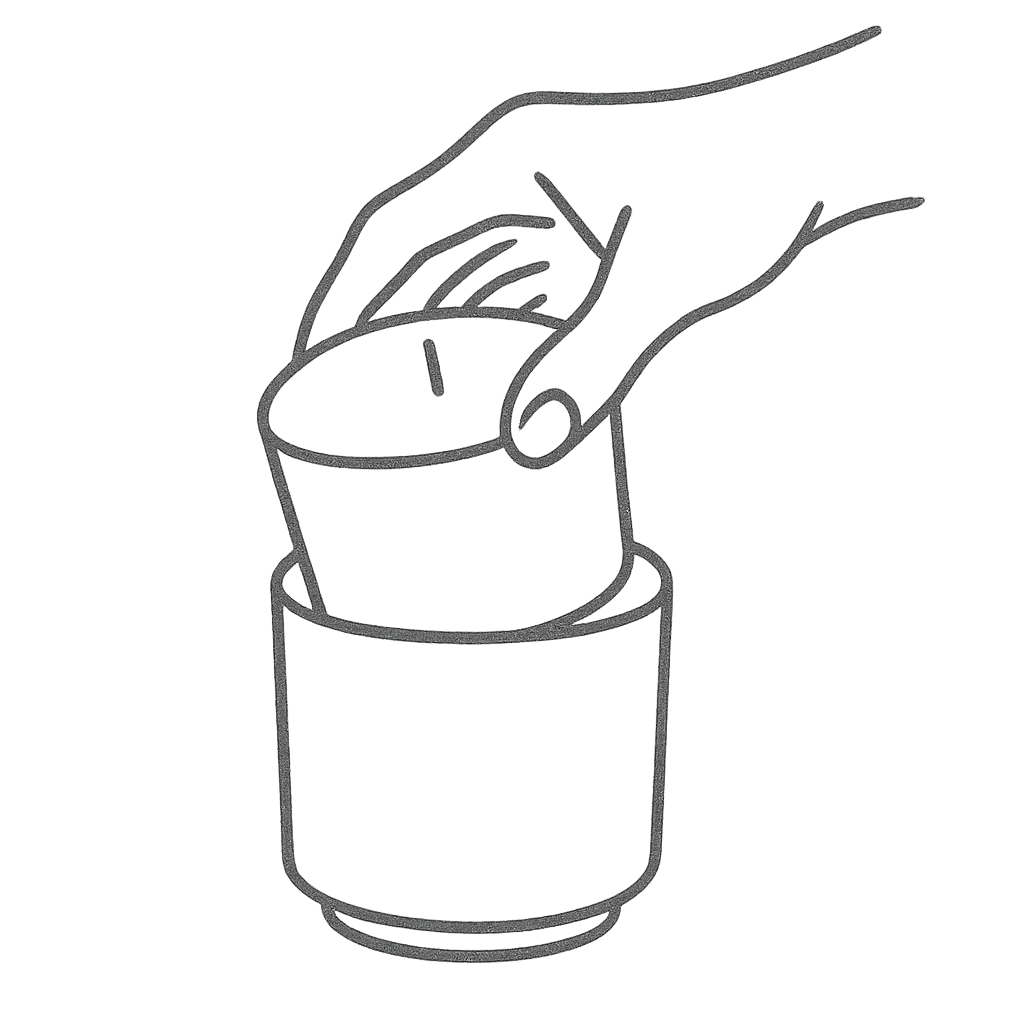 Line drawing of a hand placing a candle refill into an Analogy candle vessel